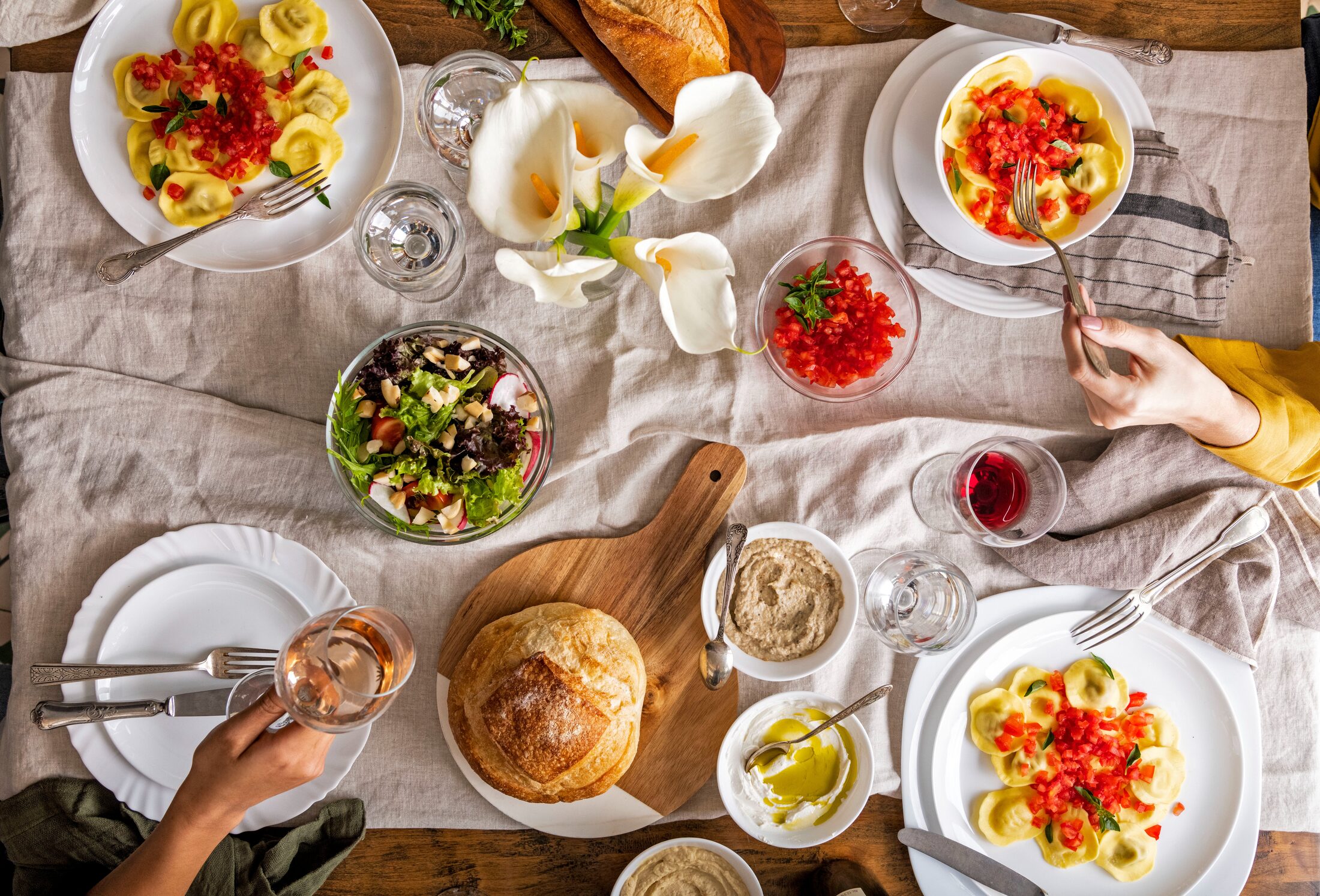 Mesa posta de almoço com massas, pães e vinho