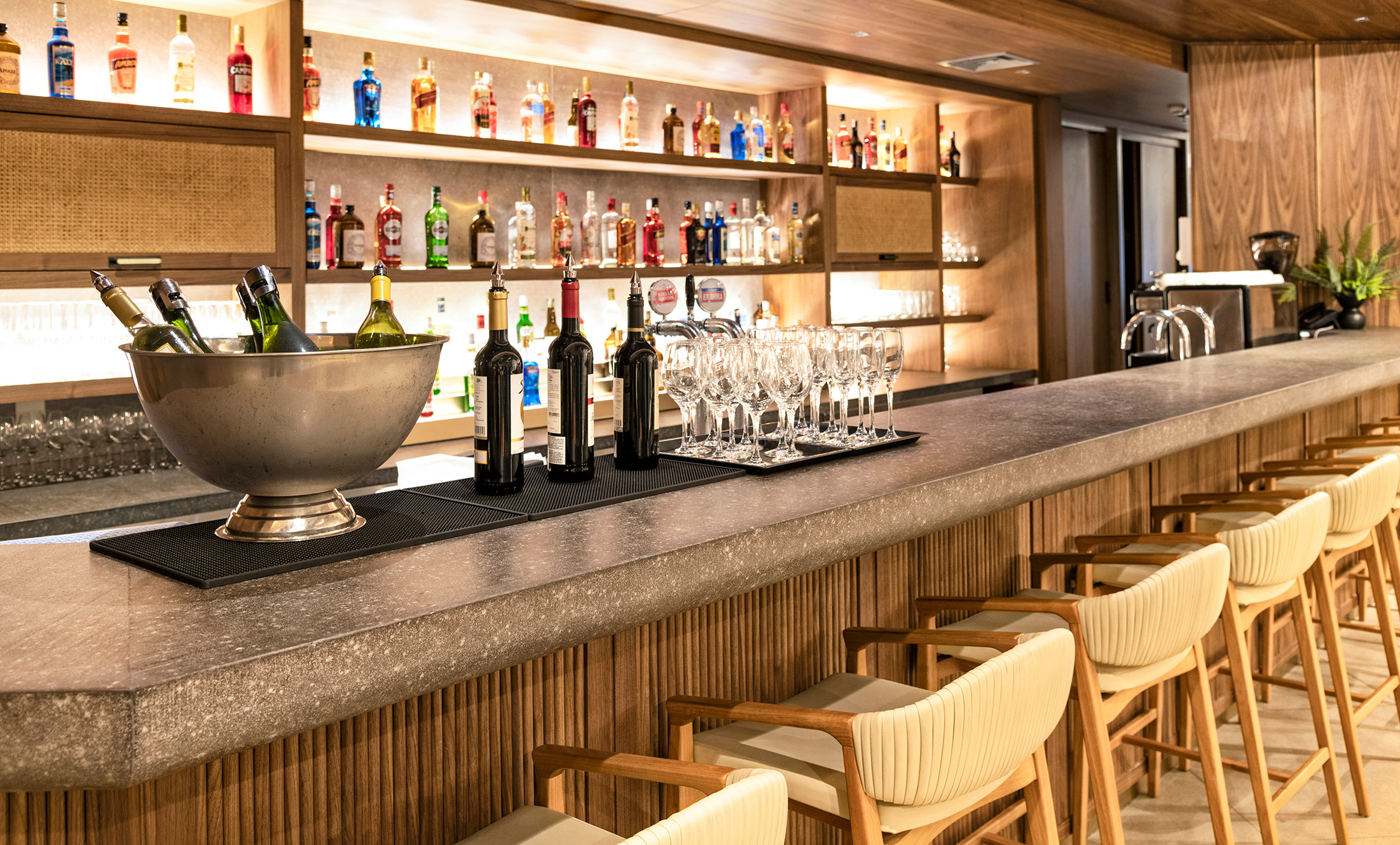 Bar do Visa Infinite Lounge com vinhos e taças